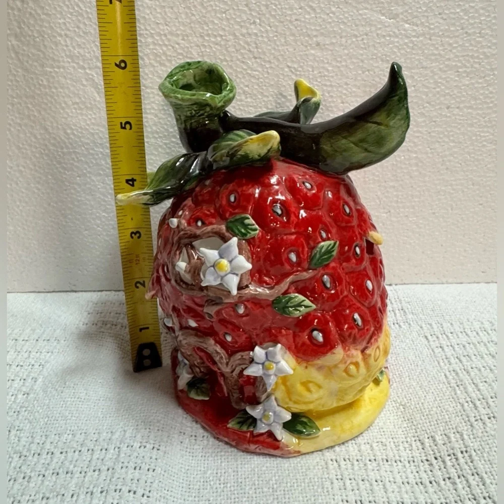 This is a vintage ceramic strawberry candle or tealight holder,